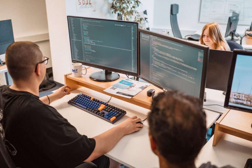 Webdesigner, der vor einem Bildschirm sitzt, auf dem Quellcode zu sehen ist, Thema ist Shopware 6 Migration