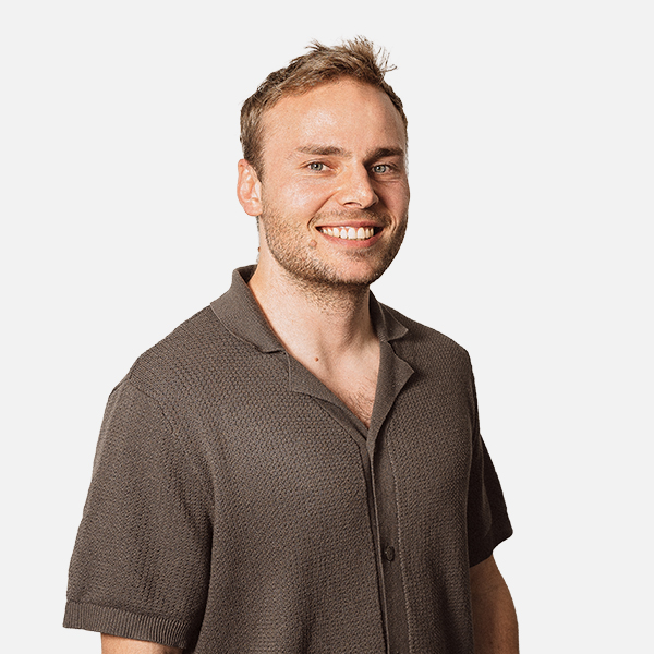 Portrait von Florian Benhauser, lächelnd, in einem kurzärmeligen Polohemd vor weißem Hintergrund.