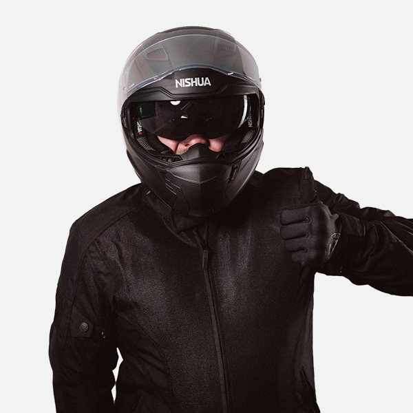 Florian Michel in kompletter Motorradmontur mit schwarzem Helm und passender schwarzer Schutzjacke. Er gibt einen Daumen hoch und steht vor einem weißen Hintergrund.
