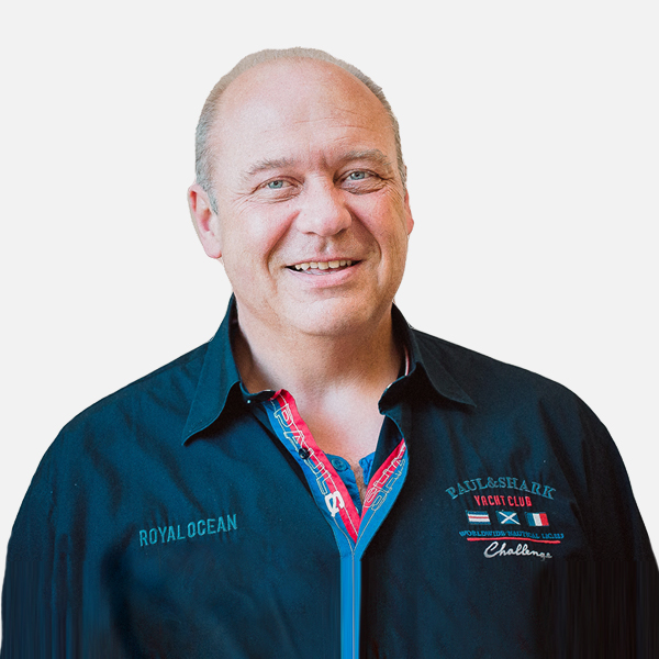 Frank Frohme mit einem freundlichen Lächeln, trägt ein dunkelblaues Hemd vor weißem Hintergrund