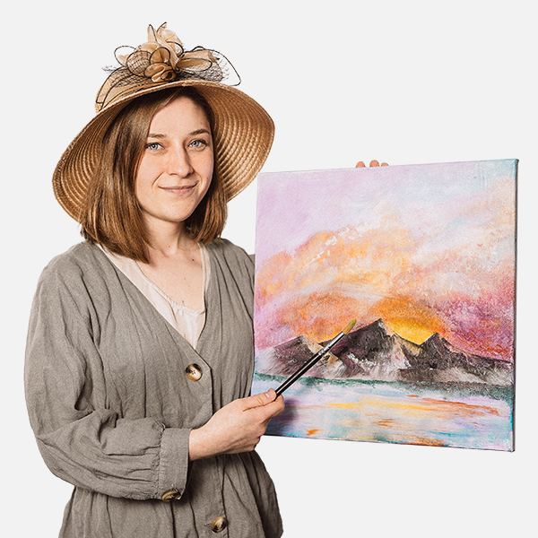 Joline Siegwarth trägt einen eleganten Strohhut mit Verzierungen und hält ein selbstgemaltes Gemälde mit einer Berglandschaft und einem farbenfrohen Sonnenuntergang. Mit einem Pinsel in der Hand zeigt sie stolz auf ihr Kunstwerk.