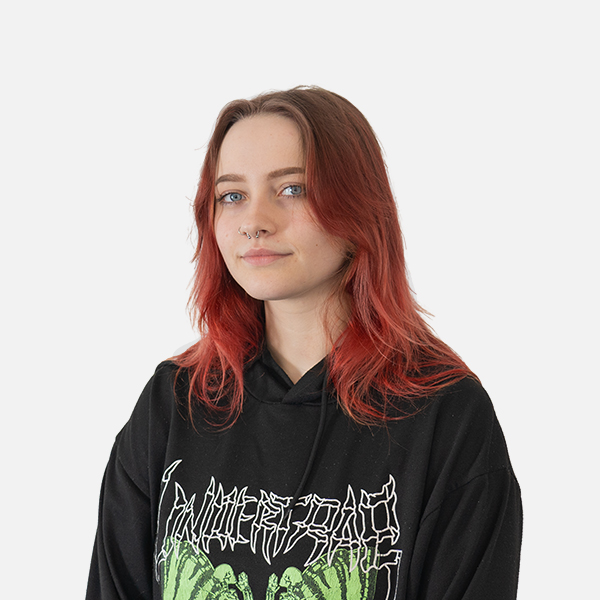 Lucie Beckmann mit rot gefärbten Haaren in einem schwarzen Hoodie vor weißem Hintergrund.