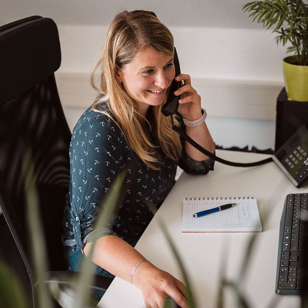 Jana führt ein Beratungsgespräch am Telefon im Büro