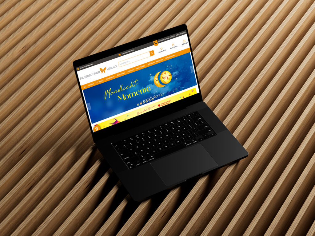 Laptop auf Holzlamellen zeigt Startseite eines Onlineshops mit Banner und Navigation.