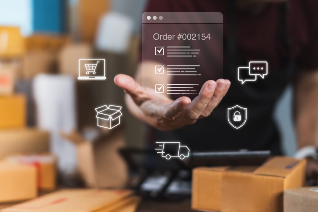 Person hält virtuelle Bestellübersicht mit Versand-, Chat- und Sicherheitssymbolen über Paketen – Darstellung eines E-Commerce-Systems mit Shopware