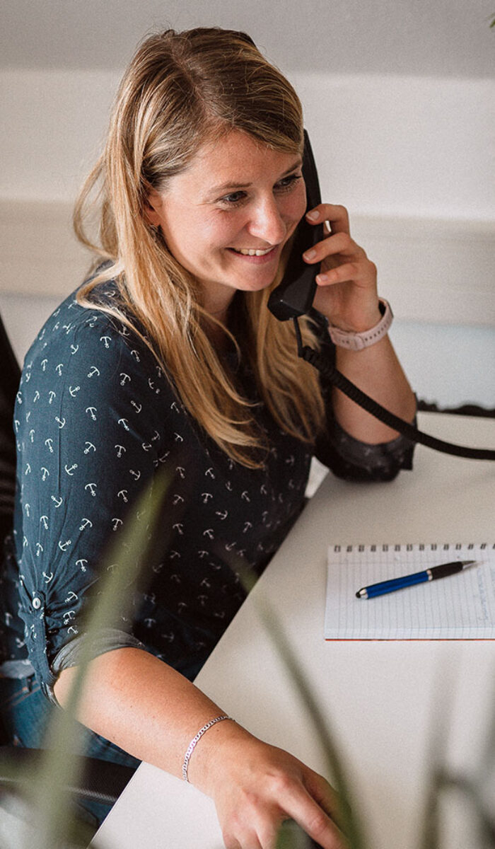 Jana führt ein Beratungsgespräch am Telefon im Büro